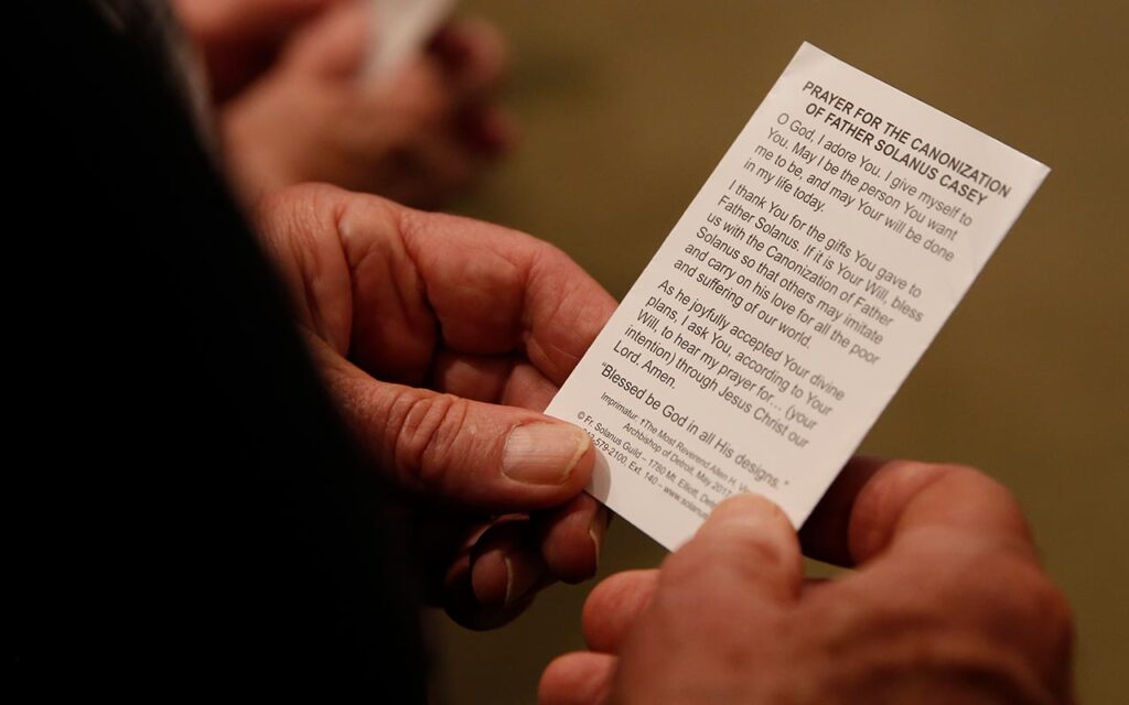 Man holding prayer card