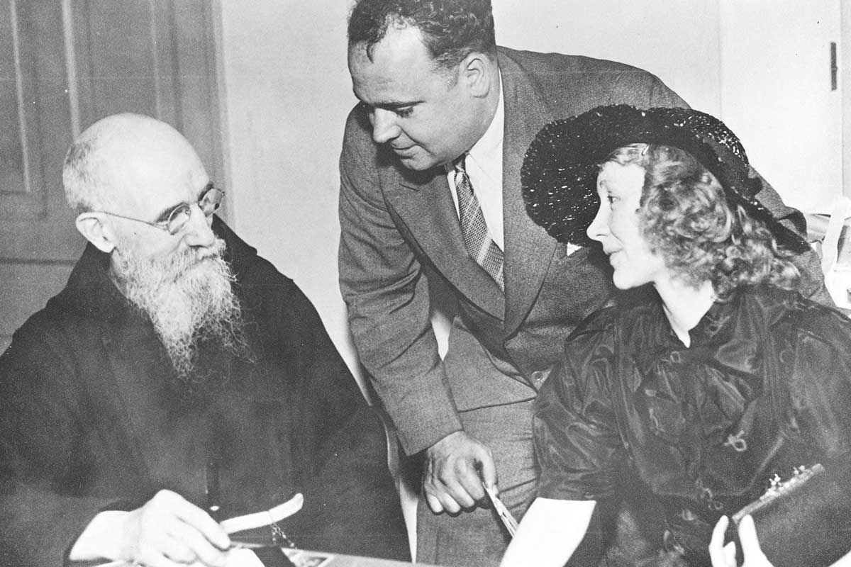 Father Solanus meeting with a couple in his office.