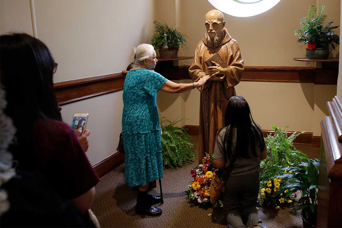 Pilgrims venerate the statue of Blessed Solanus Casey in the narthex of St. Bonaventure Chapel