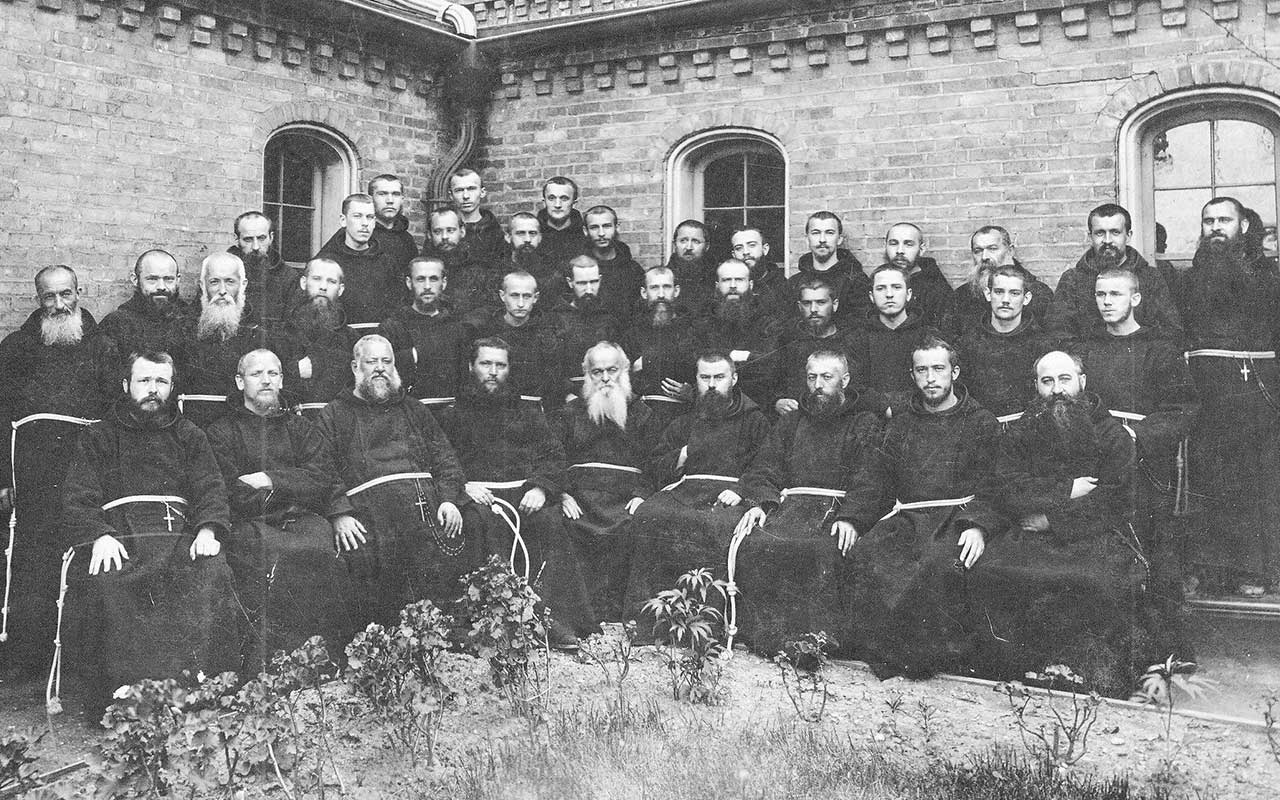 A black-and-white historic photograph of Capuchin friars and students in the courtyard of St. Francis of Assisi Monastery in Milwaukee, Wisconsin. Blessed Solanus is in the second row, seventh from left.