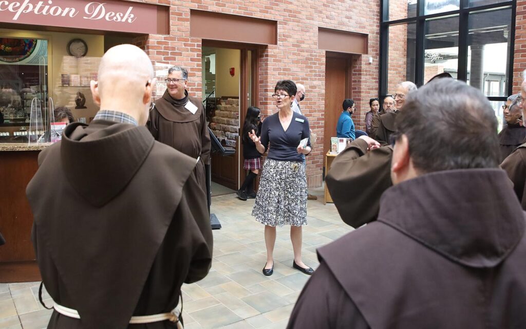 OFM and Capuchin pilgrims touring the Solanus Casey Center with Hospitality Coordinator Sally McCuen leading the group on a tour.