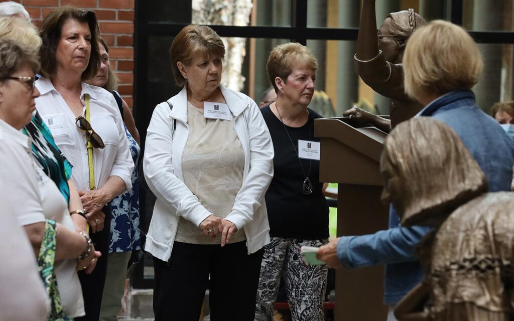 Photo of a tour group from St. Michael Parish viewing the Beatititude Statues inside the Solanus Casey Center in Detroit, Michigan.