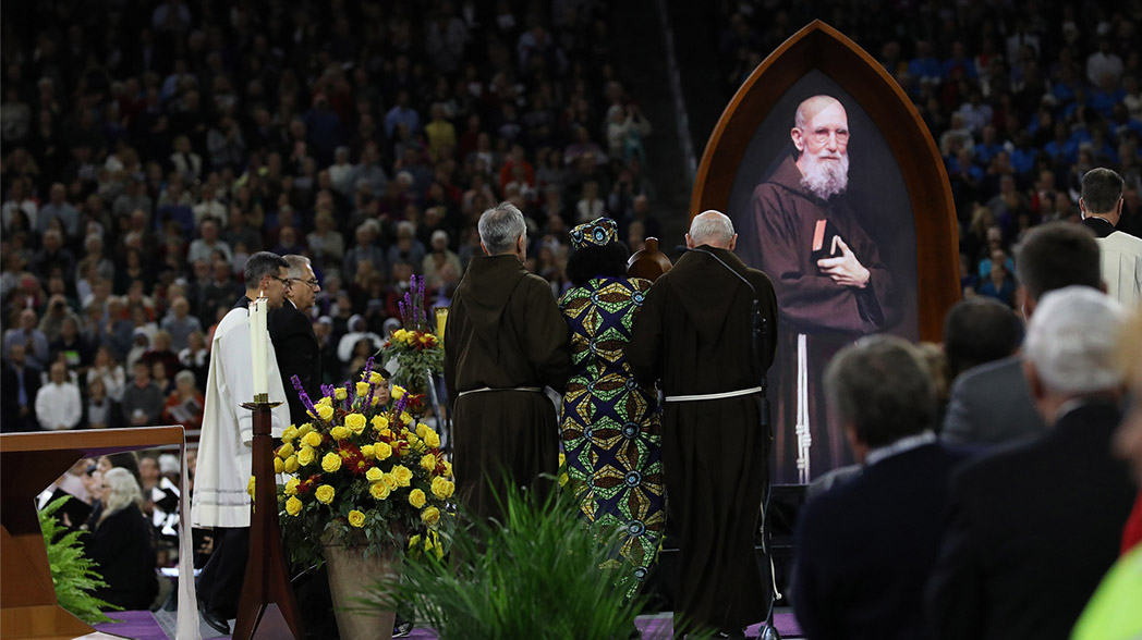 Br. Josef Timmers and Br. Michael Sullivan accompany Paula Medina-Zarate to the sanctuary with a relic of Blessed Solanus Casey during the Beatification Mass at Ford Field on November 18, 2017.