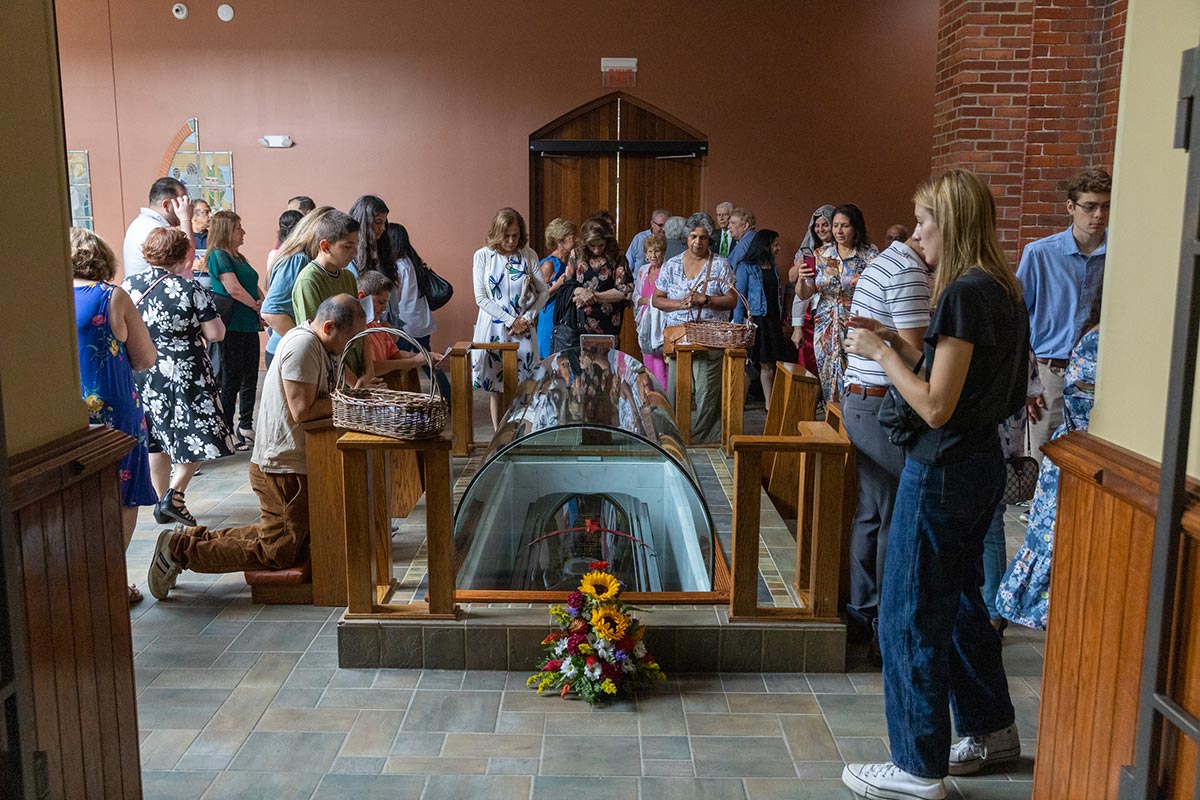 Visitors pray at the tomb of Father Solanus Casey.